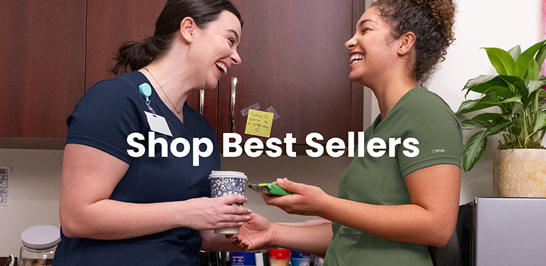 Two women in a kitchen setting in scrubs with text overlay 'Shop Best Sellers'.