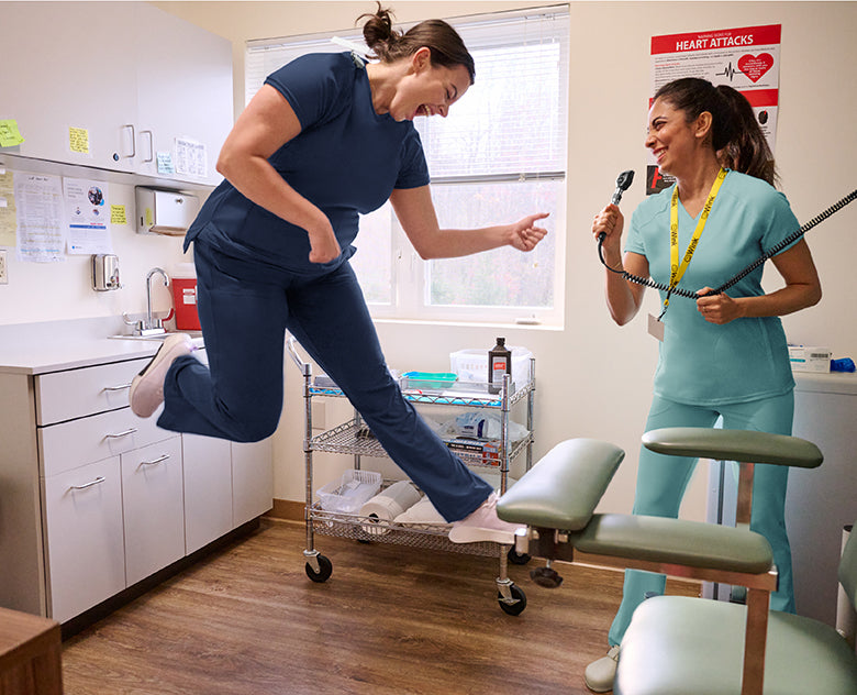 Two healthcare professionals in a clinical setting in scrubs