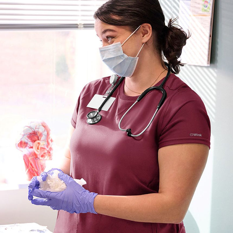 woman in knit scrubs in a doctors office